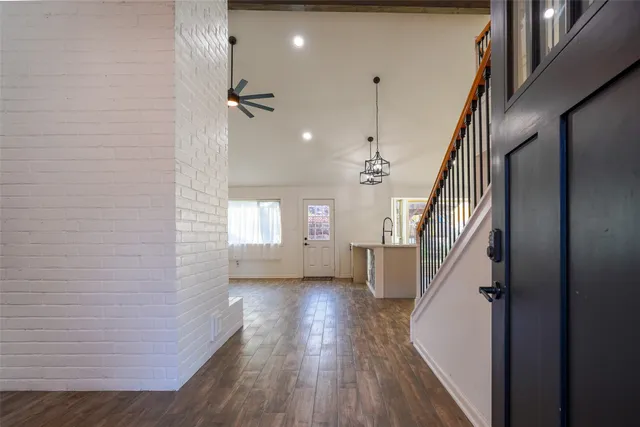 a view of a hallway with wooden floor and staircase
