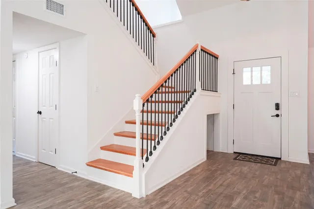 a view of staircase with wooden floor and white walls