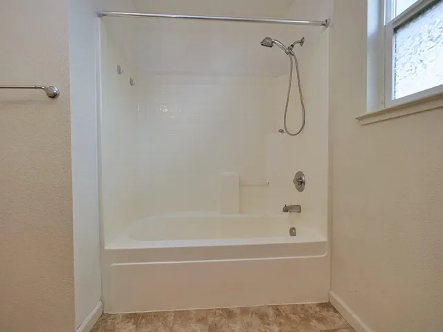 a bathroom with a bath tub with a shower