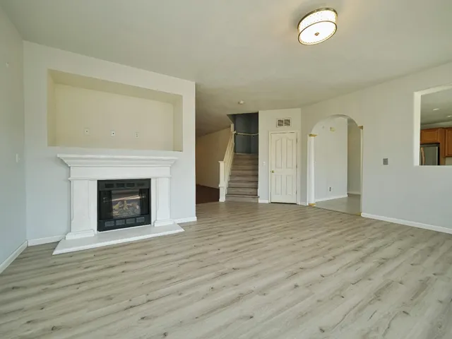 a view of a livingroom with wooden floor and a fireplace