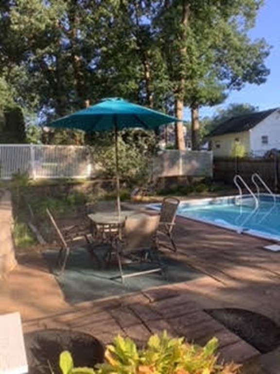 173 Cottage Road Enfield, CT 06082 - Photo 13 of 41 a view of a patio with table and chairs under an umbrella