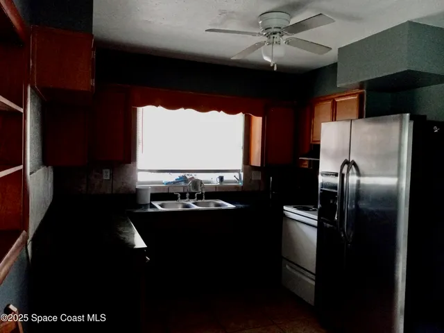 a kitchen with refrigerator and window