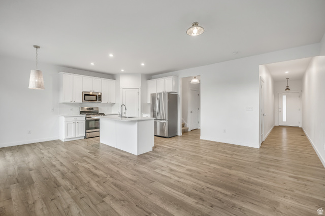 1058 Lilac Way Mapleton, UT 84664 - Photo 28 of 28 Kitchen with decorative light fixtures, open floor plan, white cabinetry, appliances with stainless steel finishes, and recessed lighting