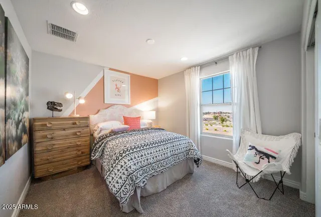 a bedroom with a bed and a chair