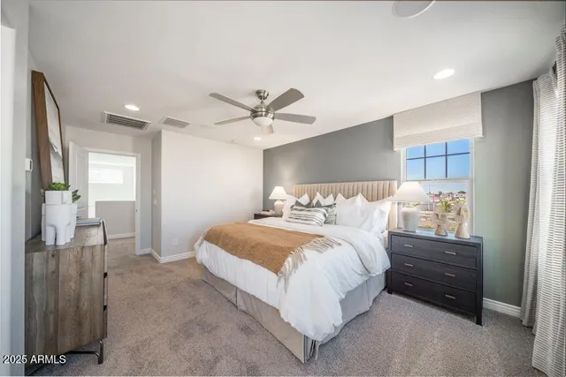 a spacious bedroom with a bed and a chandelier