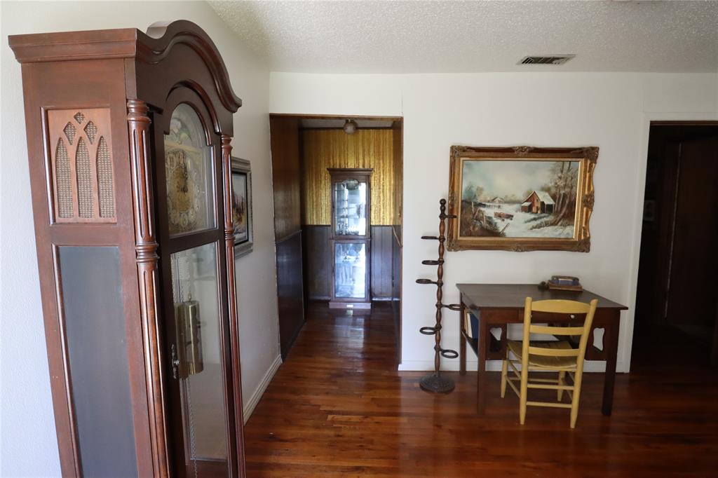 301 Travis Street Ranger, TX 76470 - Photo 11 of 31 a view of a hallway with wooden floor windows and a livingroom