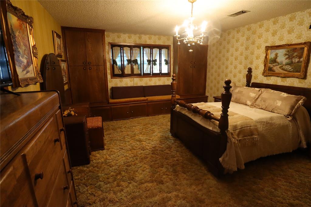 301 Travis Street Ranger, TX 76470 - Photo 13 of 31 a bedroom with a bed dresser and a flat tv screen