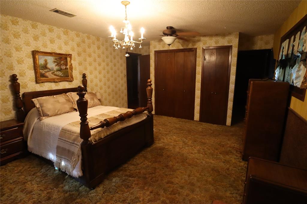 301 Travis Street Ranger, TX 76470 - Photo 14 of 31 a bed room with furniture and a chandelier
