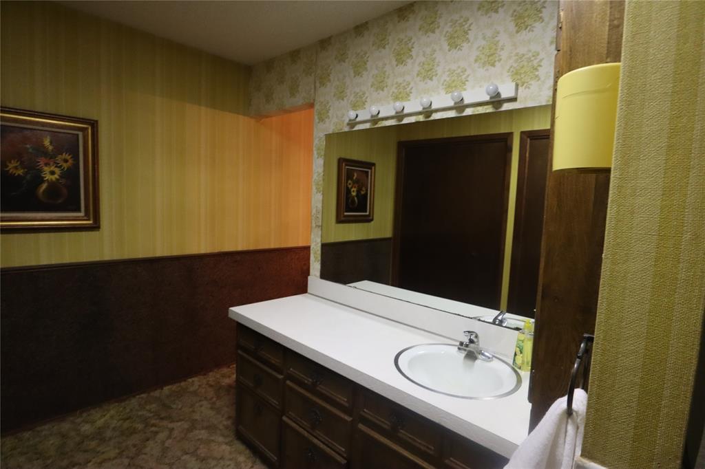 301 Travis Street Ranger, TX 76470 - Photo 17 of 31 a bathroom with a sink and a mirror