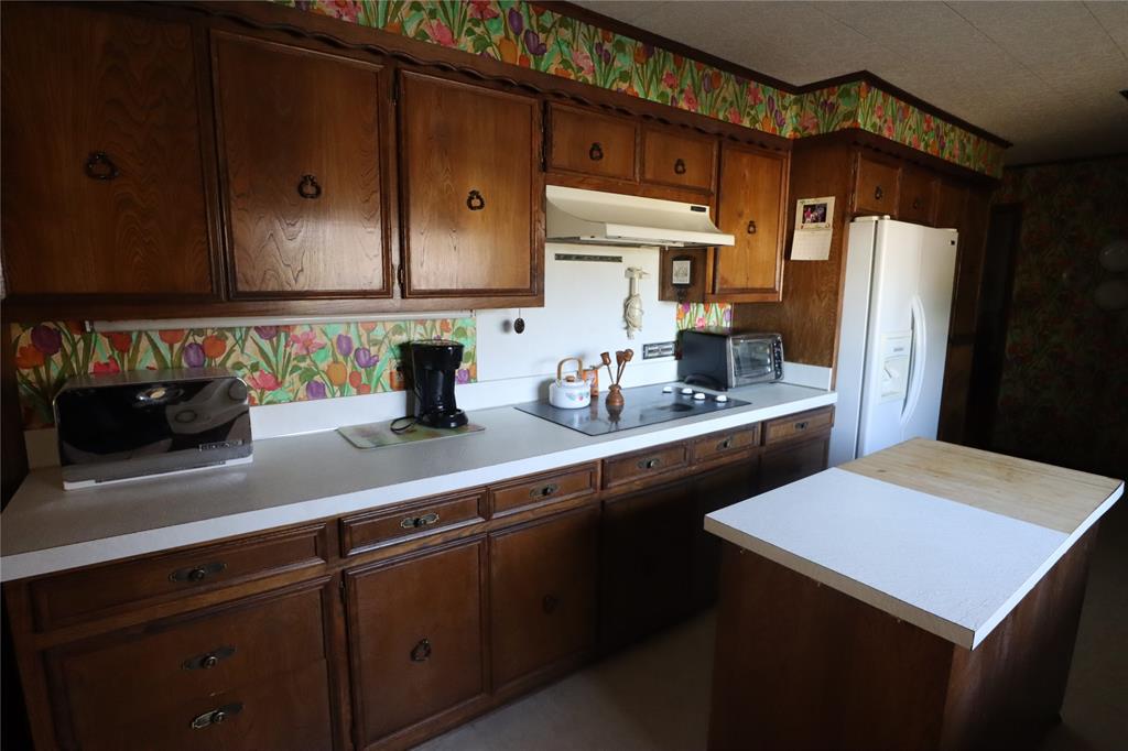 301 Travis Street Ranger, TX 76470 - Photo 26 of 31 a kitchen with stainless steel appliances a sink cabinets and wooden floor