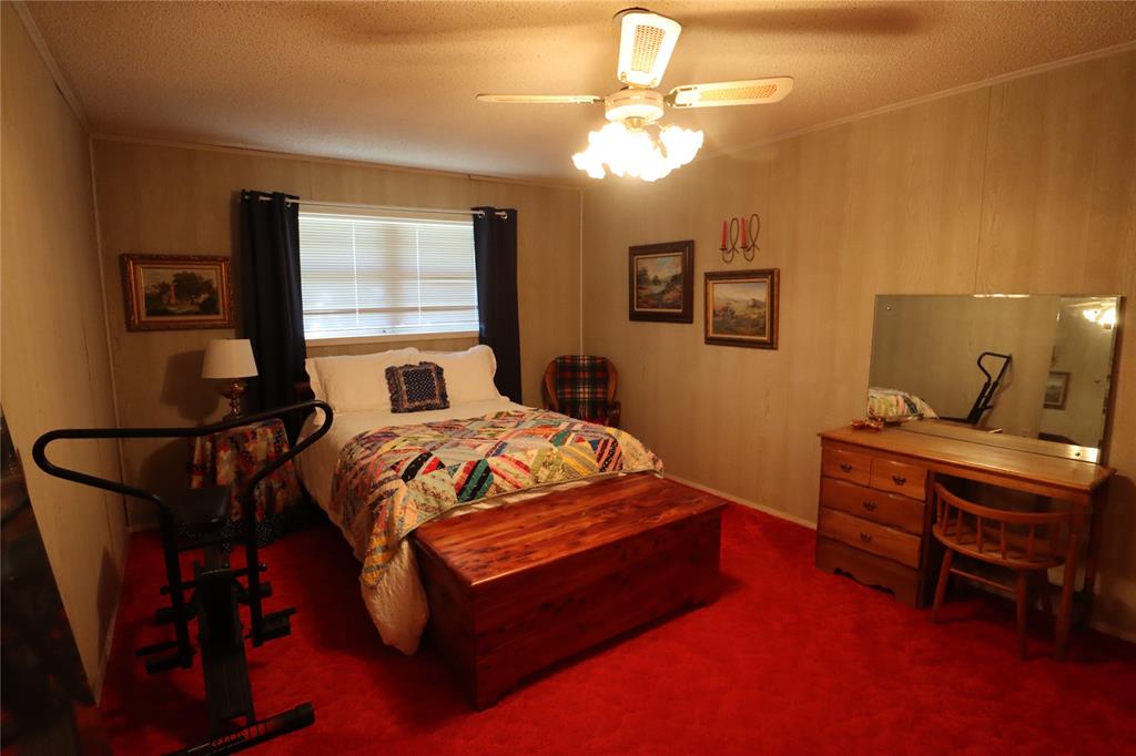 301 Travis Street Ranger, TX 76470 - Photo 29 of 31 a bedroom with a bed and a chandelier
