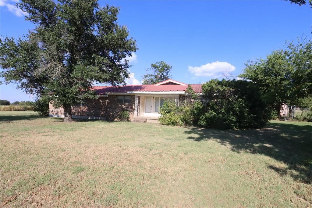 301 Travis Street Ranger, TX 76470 - Photo 5 of 31 a front view of a house with a garden and tree