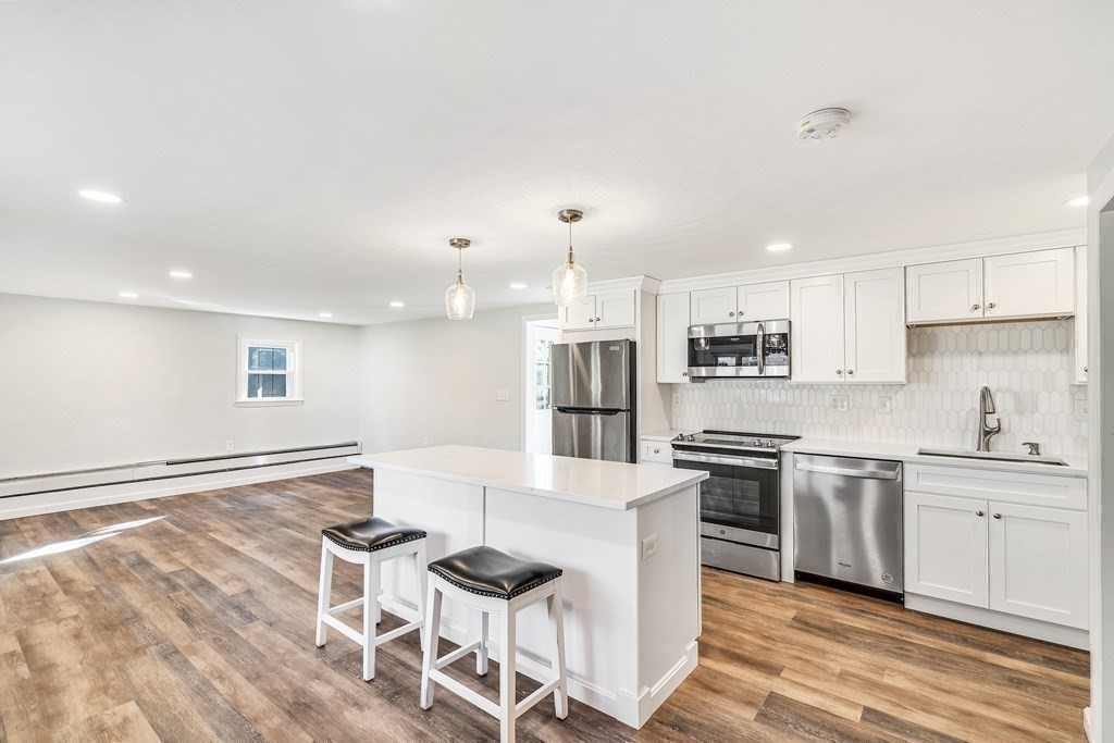 340 Berlin Road Marlborough, MA 01752 - Photo 3 of 42 a kitchen with stainless steel appliances kitchen island granite countertop a stove a sink a refrigerator and white cabinets