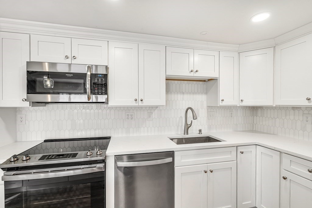 340 Berlin Road Marlborough, MA 01752 - Photo 9 of 42 a kitchen with white cabinets and appliances