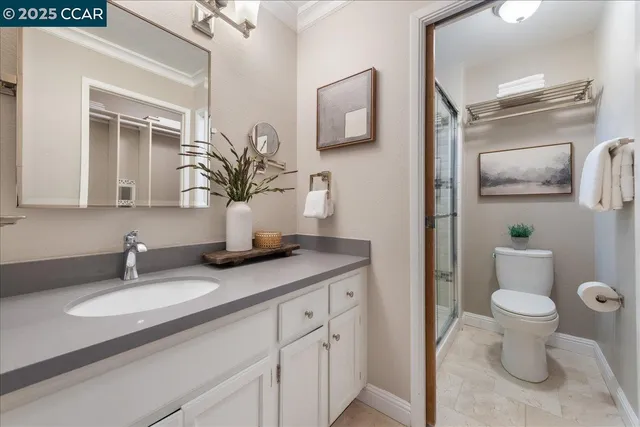a bathroom with a granite countertop sink toilet and mirror