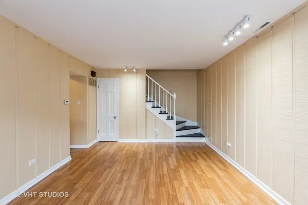 a view of a hallway with wooden floor and staircase