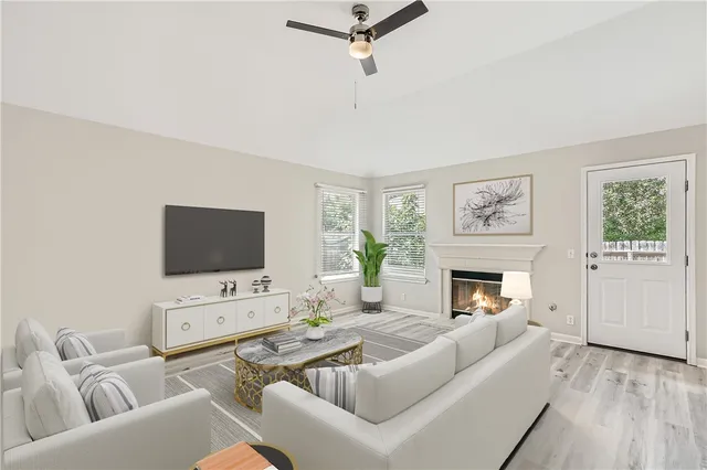 a living room with furniture a fireplace a flat screen tv and a window