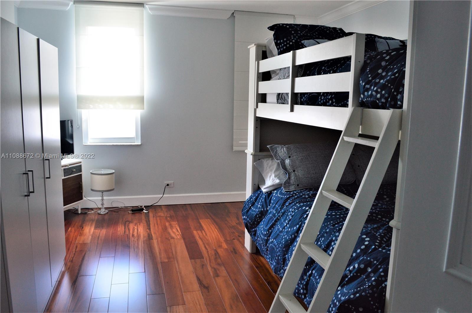 701 Brickell Key Boulevard, Unit 1203 Miami, FL 33131 - Photo 11 of 34 a view of walk in closet with wooden floor and windows