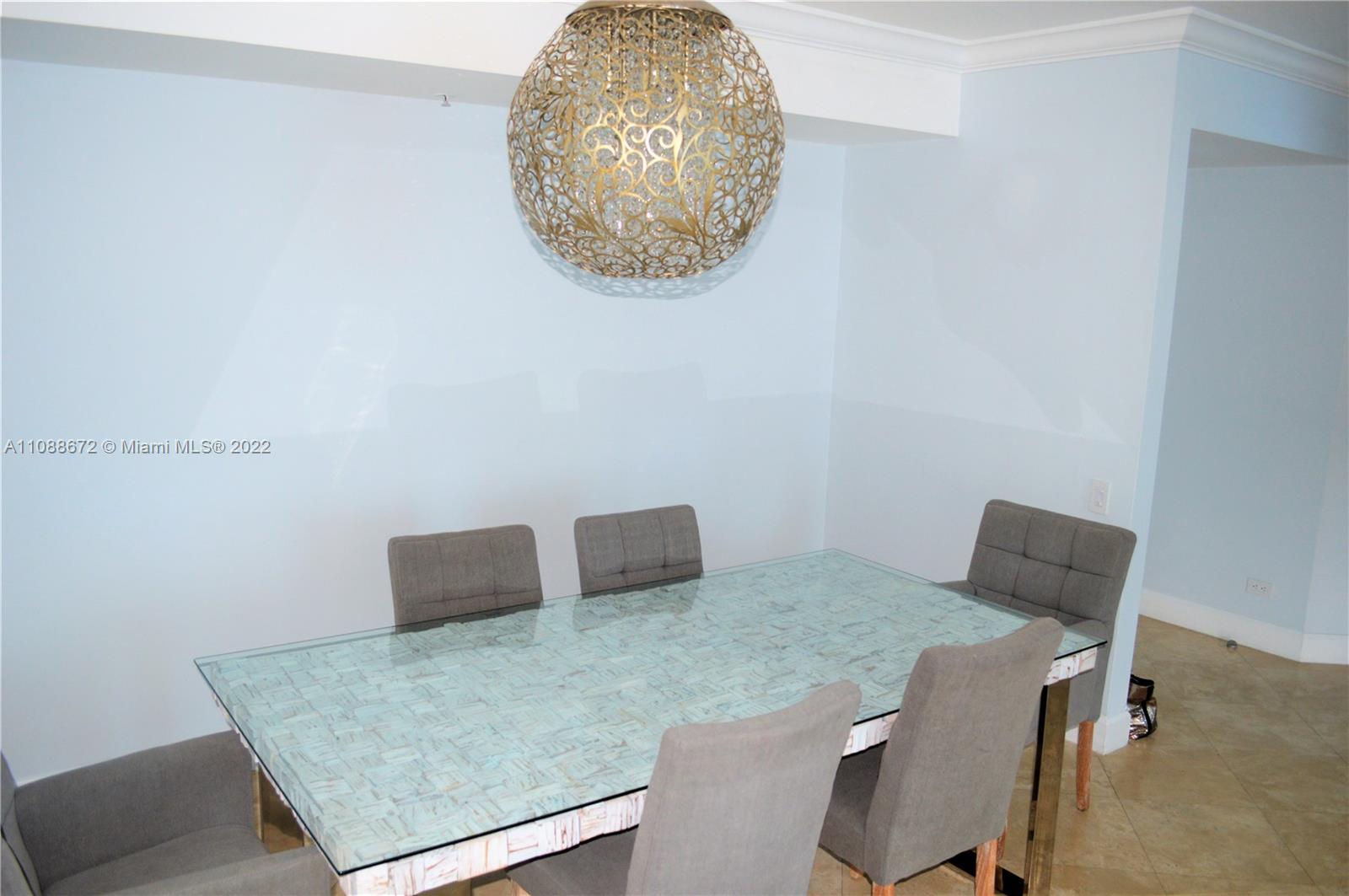 701 Brickell Key Boulevard, Unit 1203 Miami, FL 33131 - Photo 14 of 34 a table and chair in a room