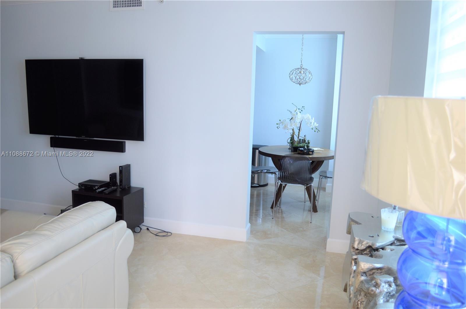 701 Brickell Key Boulevard, Unit 1203 Miami, FL 33131 - Photo 15 of 34 a living room with furniture and a flat screen tv
