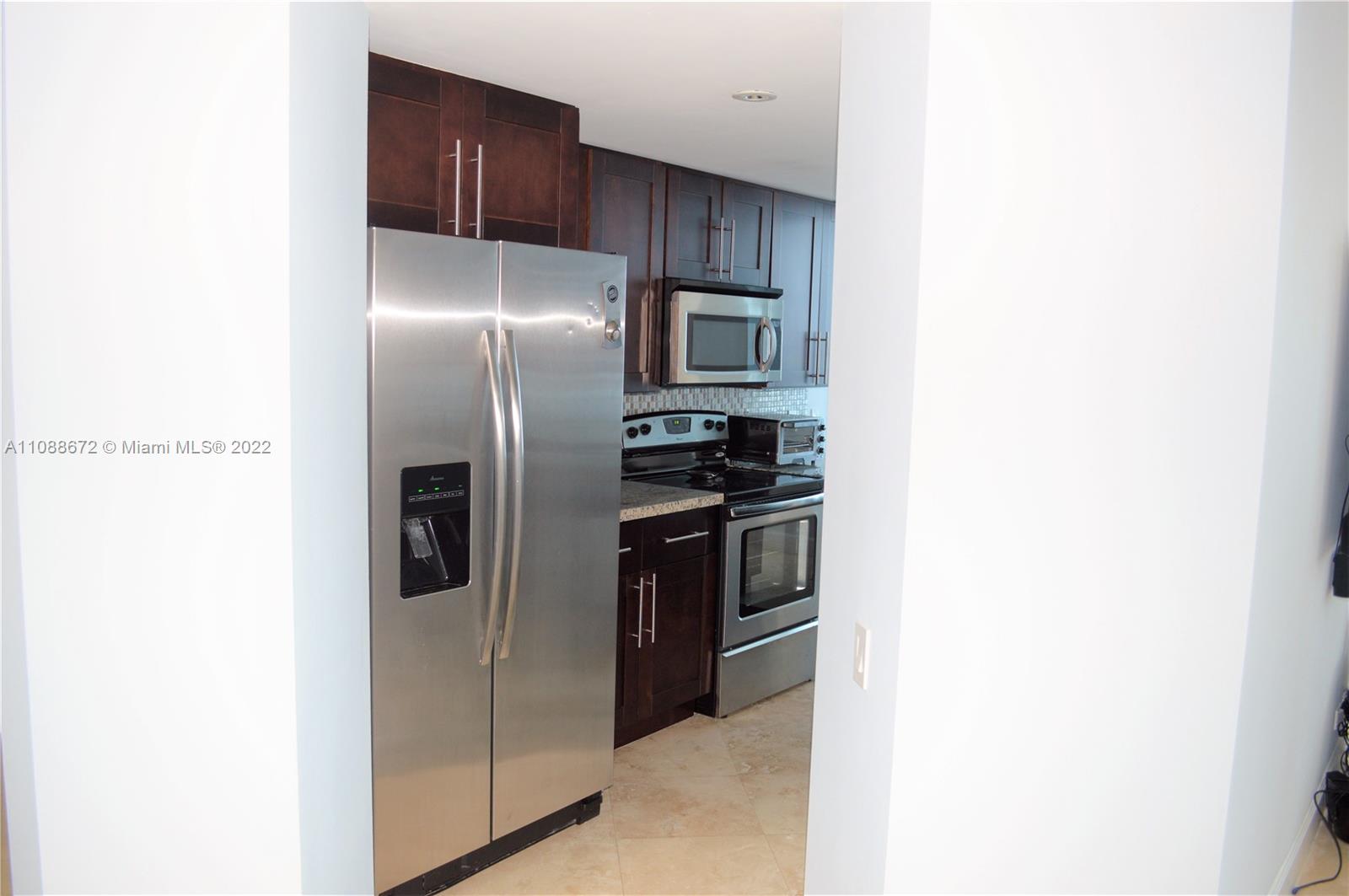 701 Brickell Key Boulevard, Unit 1203 Miami, FL 33131 - Photo 17 of 34 a metallic refrigerator freezer a stove top oven sitting inside