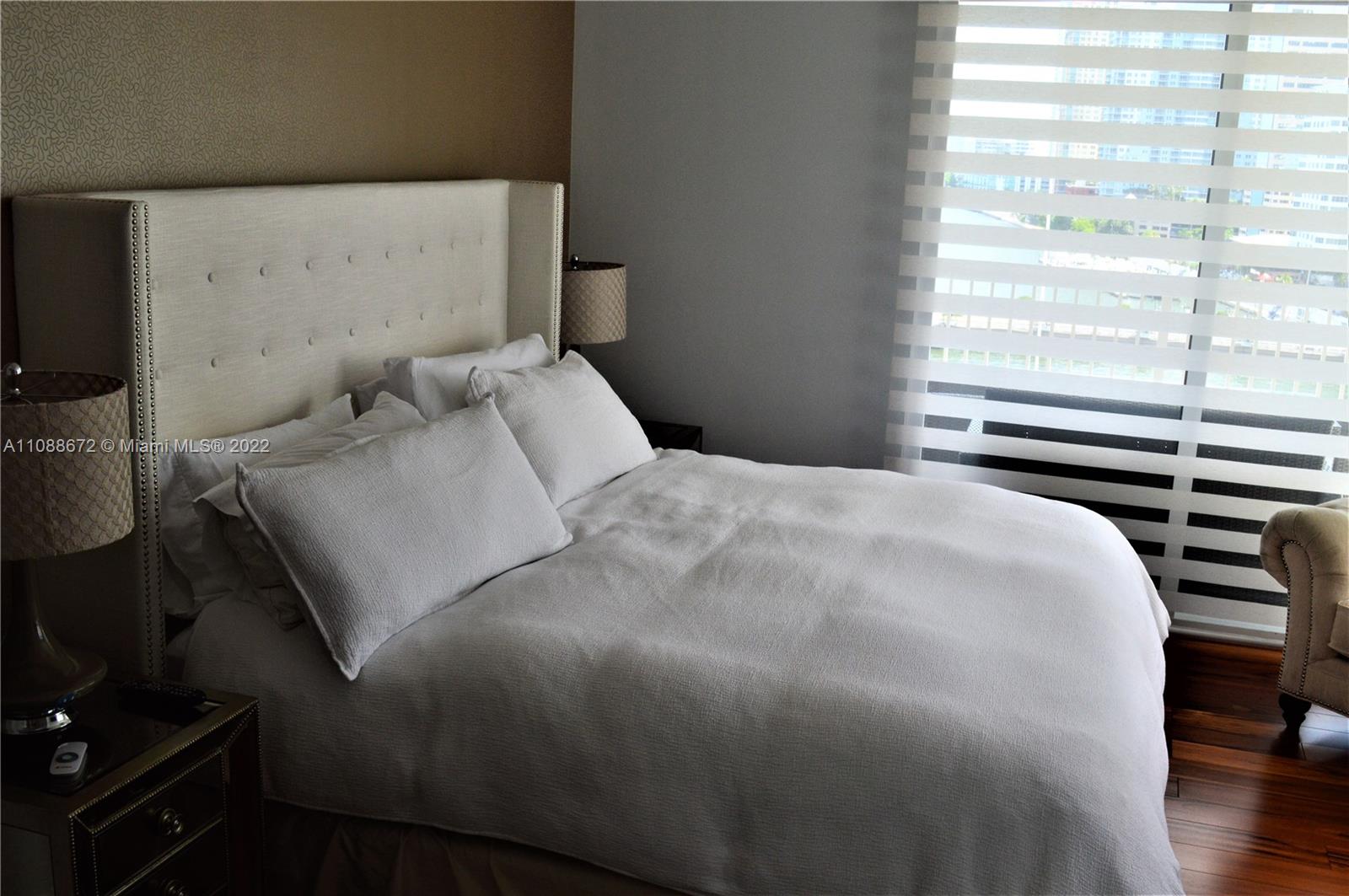 701 Brickell Key Boulevard, Unit 1203 Miami, FL 33131 - Photo 20 of 34 a bedroom with a bed and a flat tv screen on the dresser