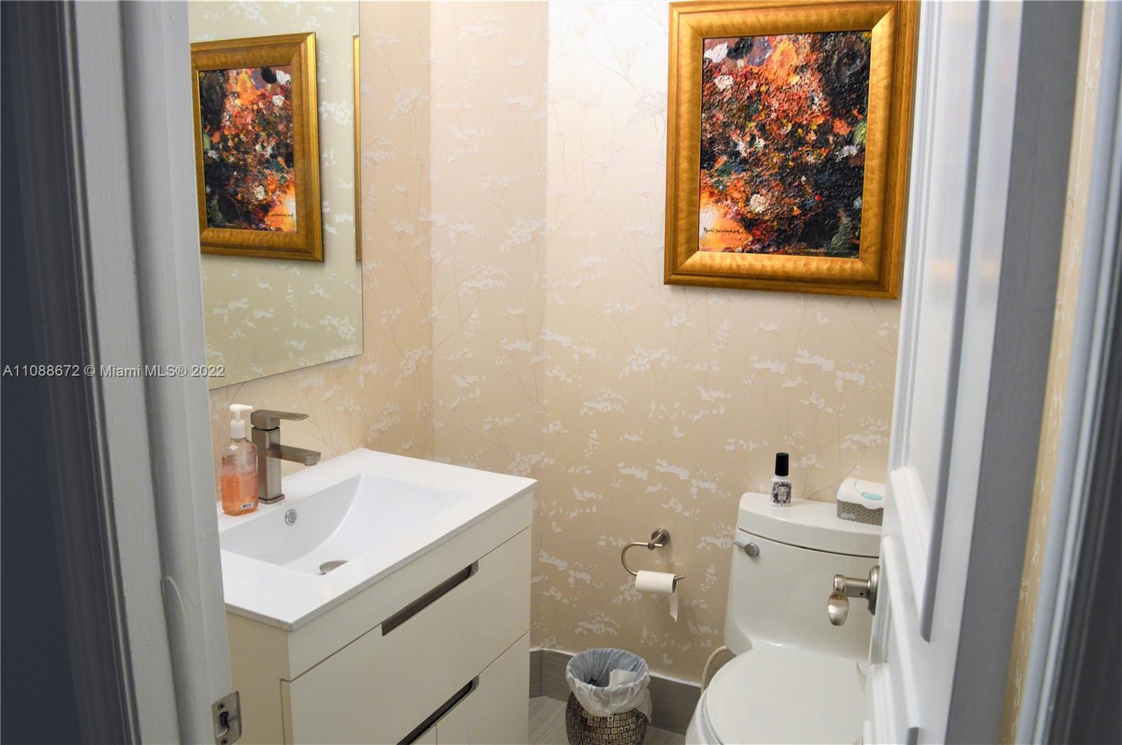 701 Brickell Key Boulevard, Unit 1203 Miami, FL 33131 - Photo 5 of 34 a bathroom with a sink mirror and toilet