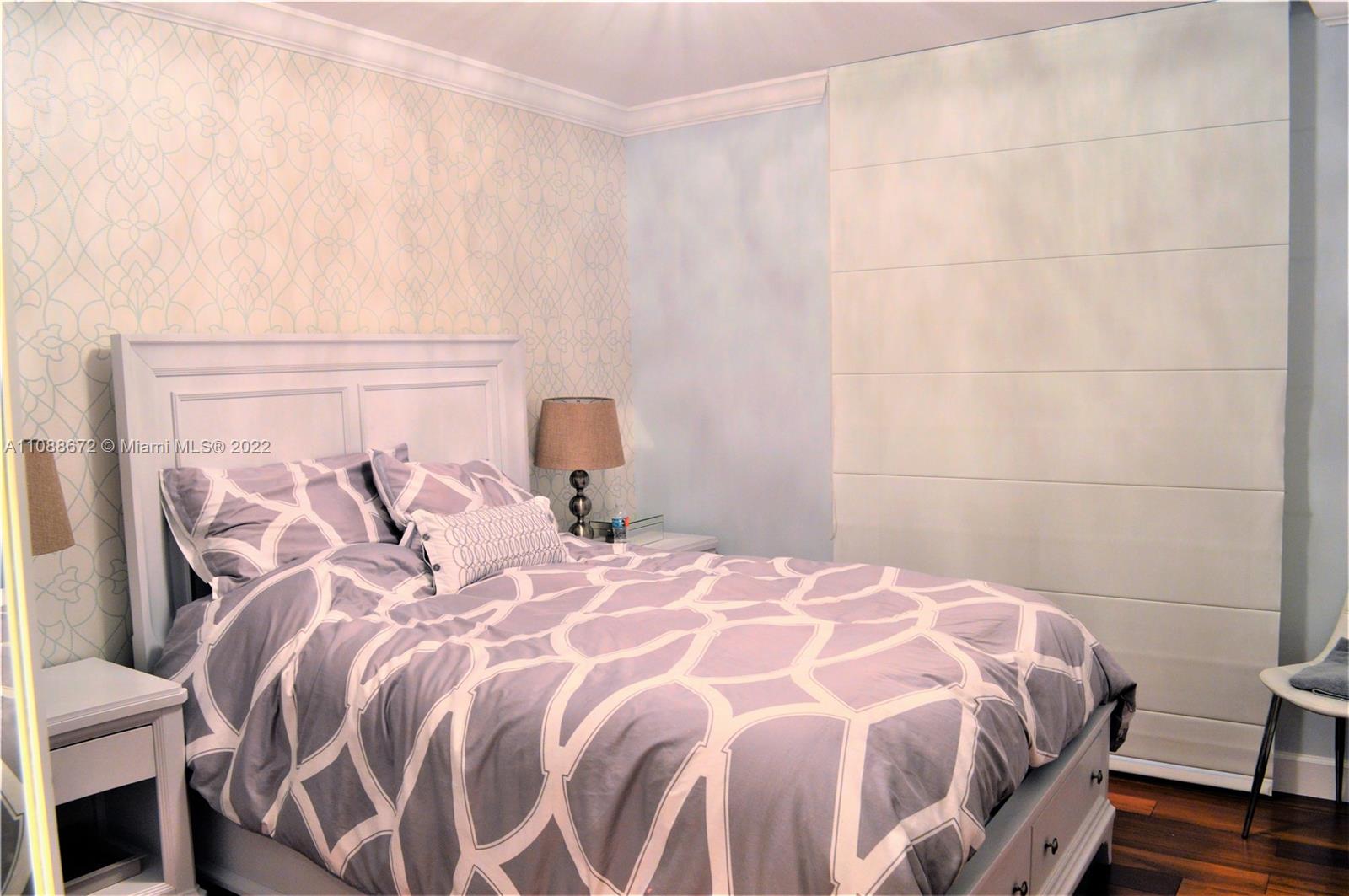 701 Brickell Key Boulevard, Unit 1203 Miami, FL 33131 - Photo 9 of 34 a bedroom with a bed and a chair