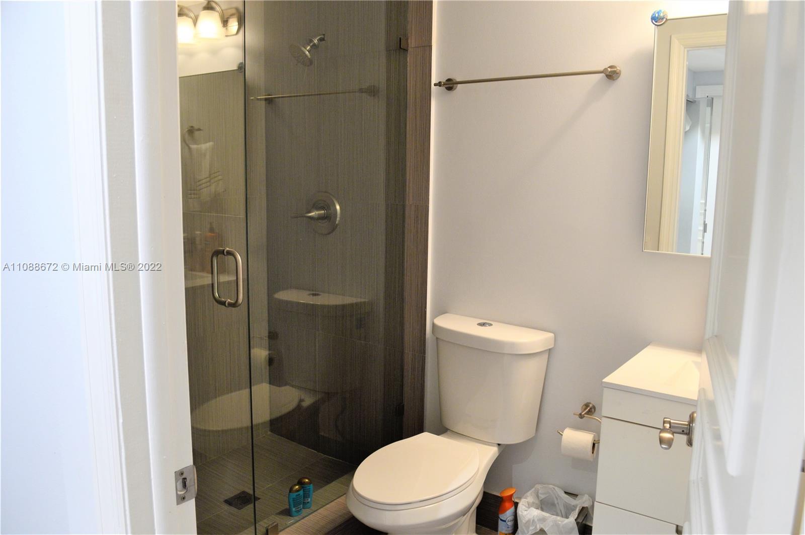 701 Brickell Key Boulevard, Unit 1203 Miami, FL 33131 - Photo 10 of 34 a white toilet sitting next to a bathroom sink