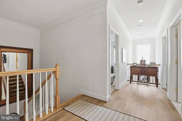 a view of a hallway with wooden floor and furniture