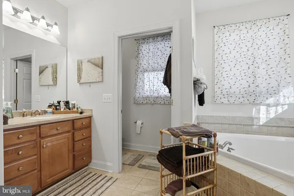 a bathroom with a tub sink and mirror