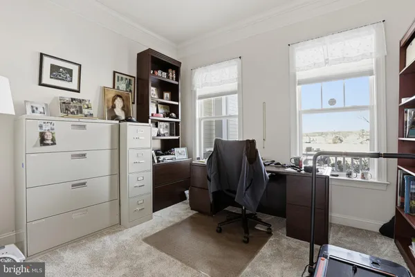a view of a workspace with furniture and a window