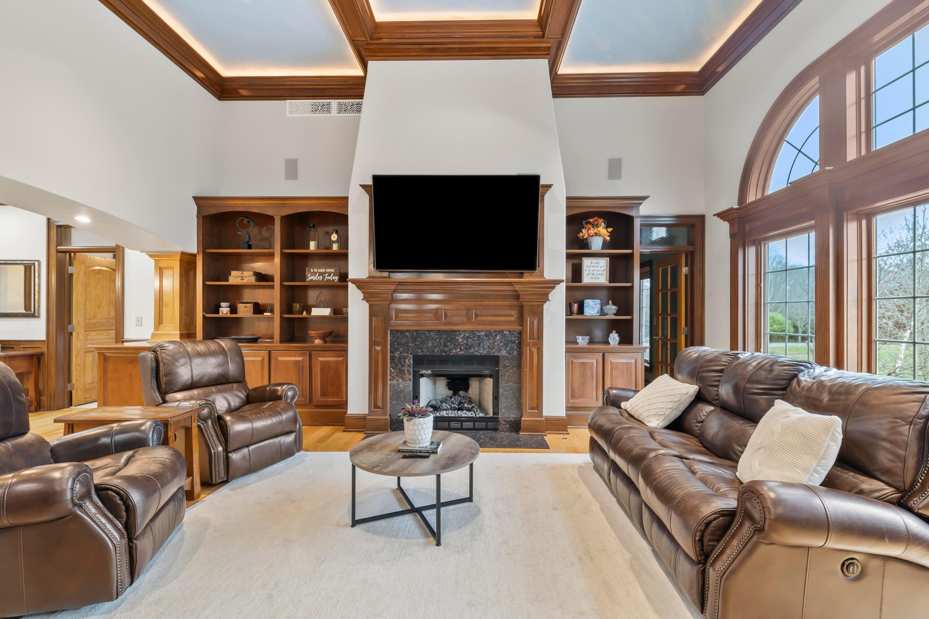 6043 Dublin Road Delaware, OH 43015 - Photo 18 of 98 • Hardwood flooring
• Ivory painted walls
• Tray ceiling
• Can lighting
• 13ft ceiling
• Built-in bookcases
• Gas fireplace with granite
surround & custom mantle
• TV does not remain
• Mount remains