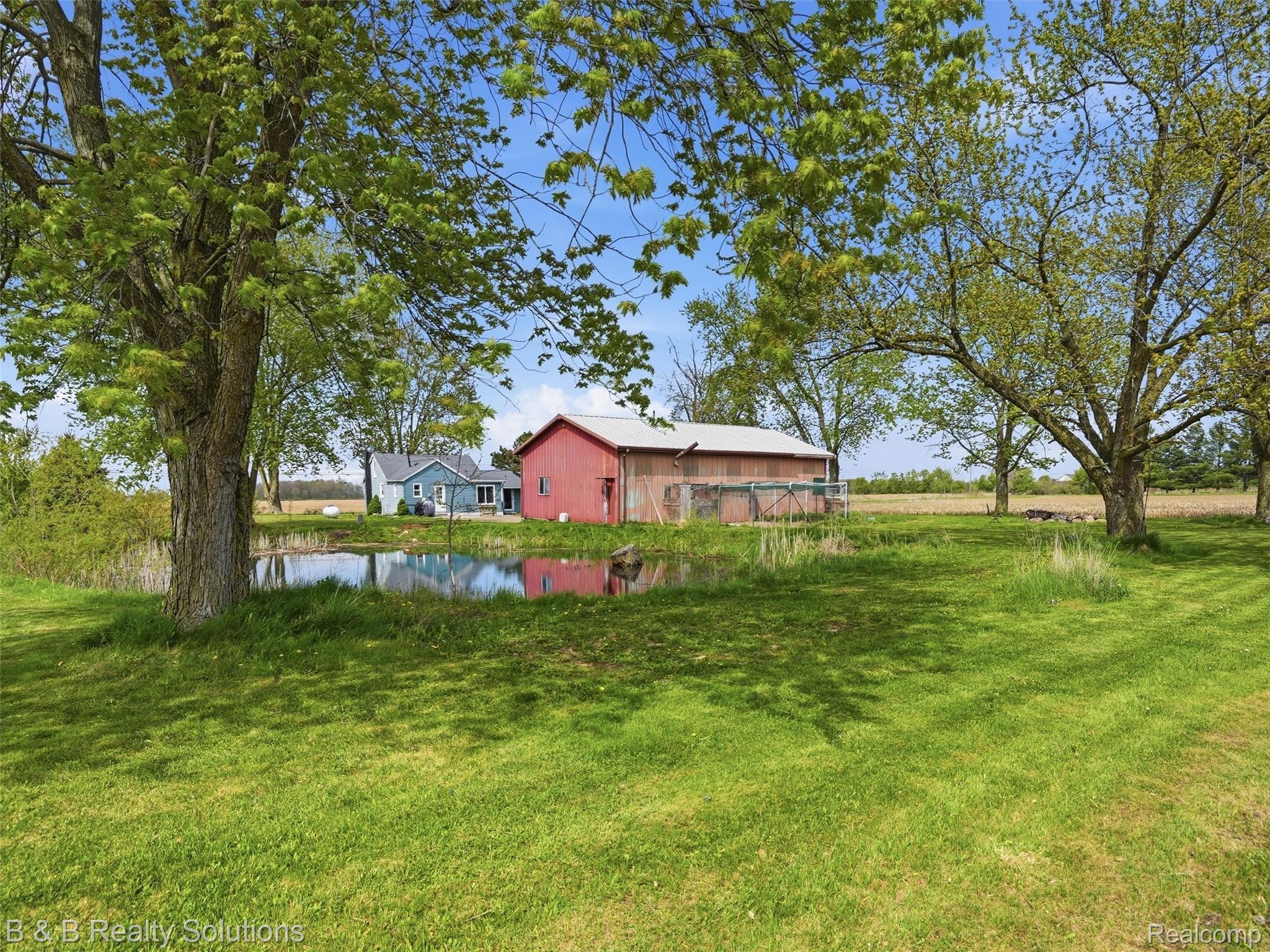 21900 Bordman Road Armada, MI 48005 - Photo 50 of 55 View of grassy yard featuring an outbuilding and a water view