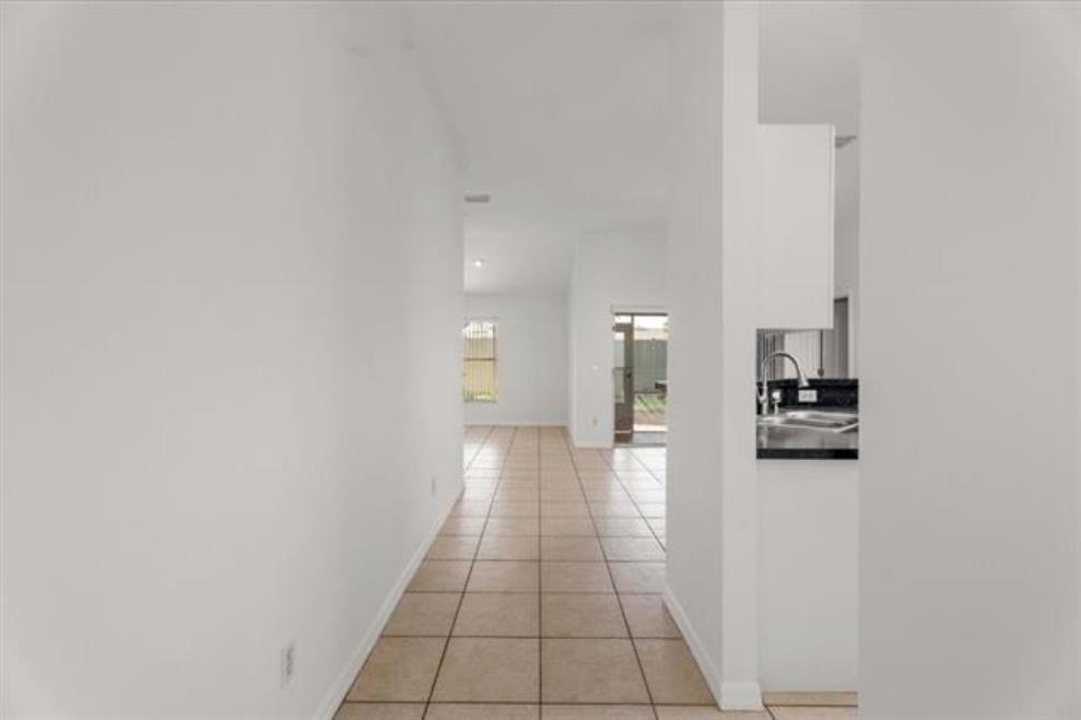 980 Windward Way St. Augustine, FL 32080 - Photo 4 of 16 a view of a hallway with wooden floor and a bathroom