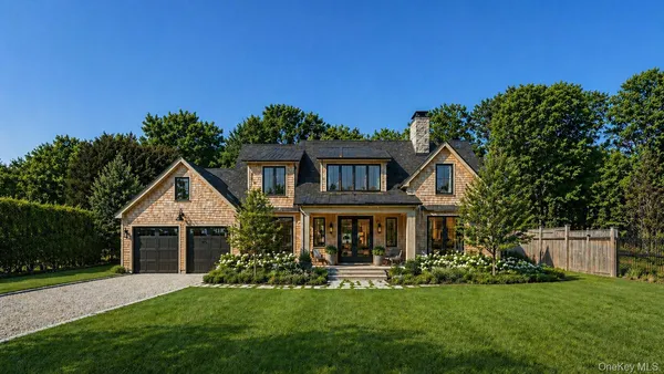 a front view of a house with a garden and yard
