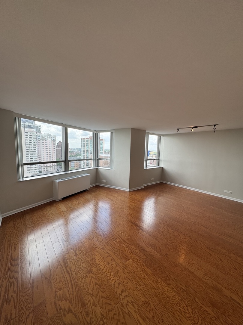 5701 North Sheridan Road, Unit 17S Chicago, IL 60660 - Photo 2 of 8 a view of empty room with wooden floor and fan