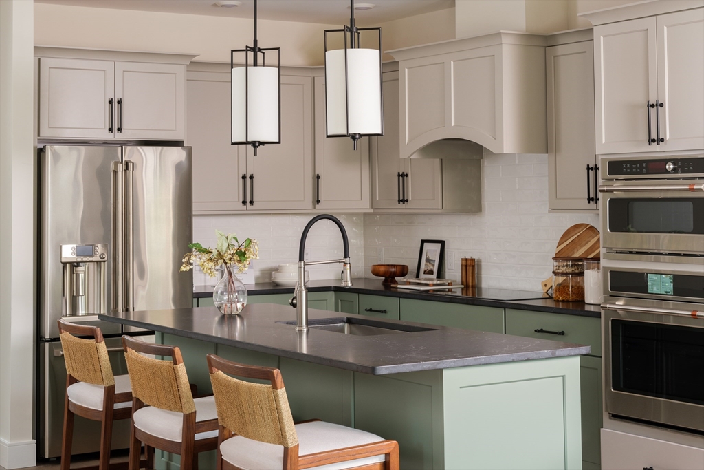643 Church Street, Unit 122 Raynham, MA 02767 - Photo 3 of 28 a kitchen with stainless steel appliances granite countertop a sink refrigerator and cabinets