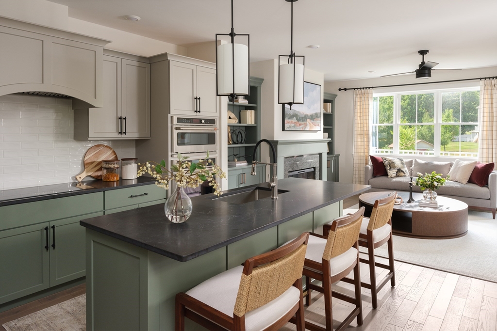 643 Church Street, Unit 122 Raynham, MA 02767 - Photo 4 of 28 a kitchen with a dining table chairs and living room view