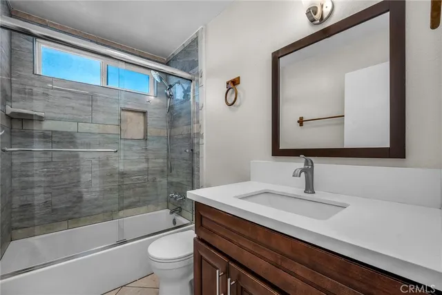 a bathroom with a sink a toilet a mirror and shower