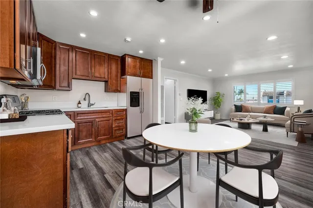 a kitchen with a dining table chairs and refrigerator