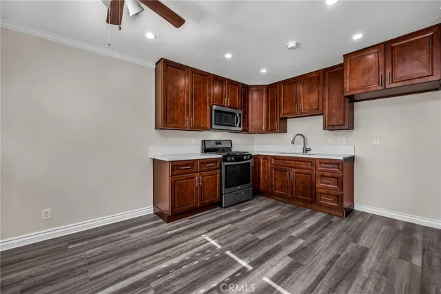 a kitchen with stainless steel appliances granite countertop a stove a sink and a microwave