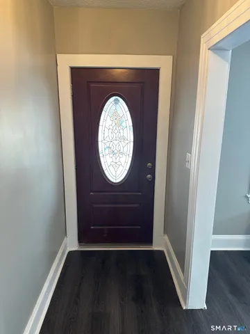 an empty room with wooden floor and hallway