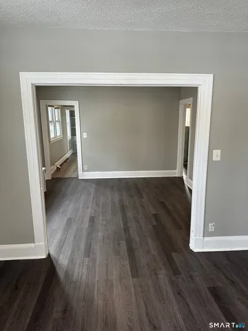 an empty room with wooden floor and a window