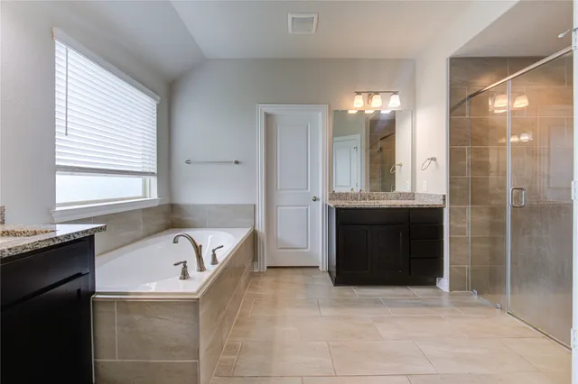 a bathroom with a tub sink and mirror
