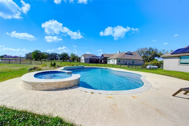 a view of a swimming pool with a yard and a fountain