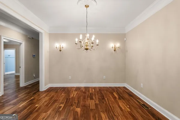 a view of a room with wooden floor and chandelier