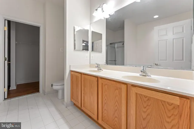 a spacious bathroom with a double vanity sink a mirror and a shower