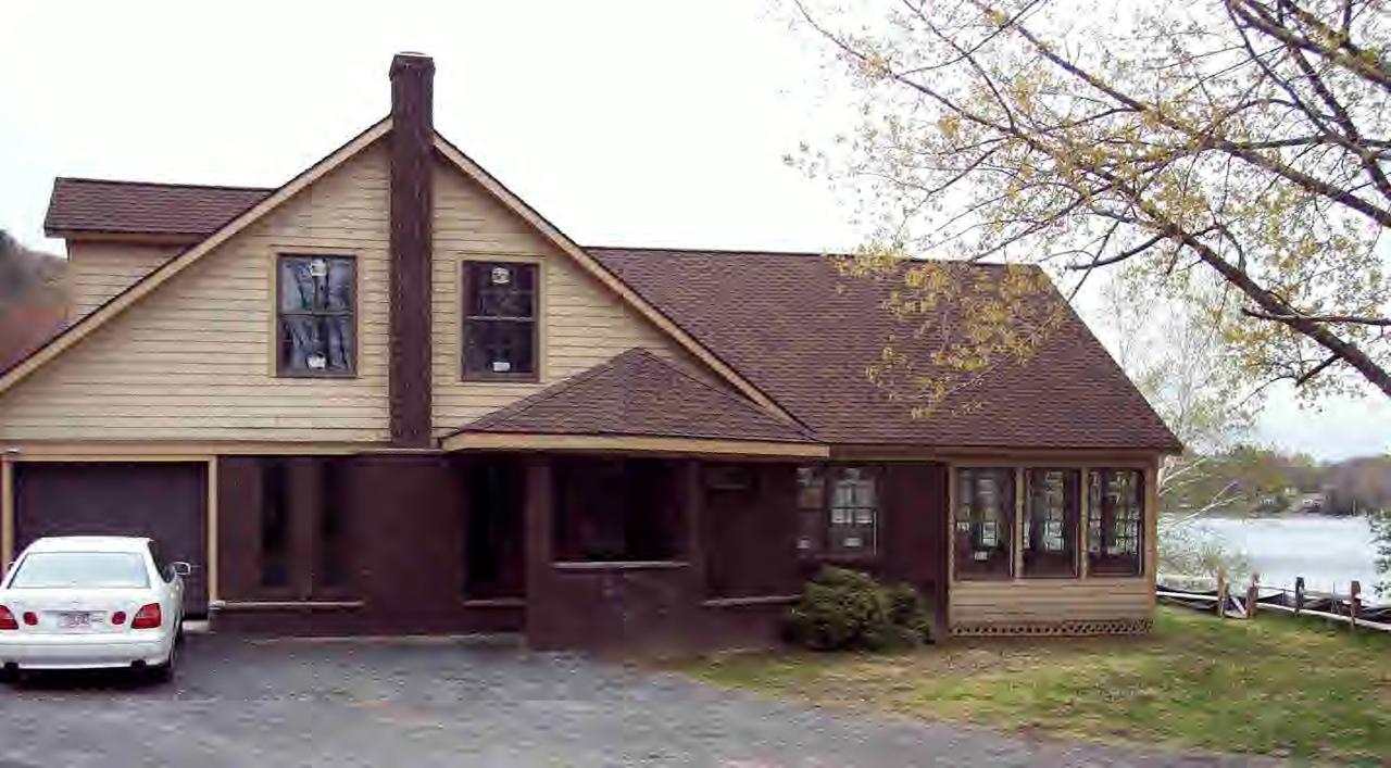 3729 Jacobs Ladder Road Becket, MA 01223 - Photo 3 of 3 a front view of a house with a garden and parking
