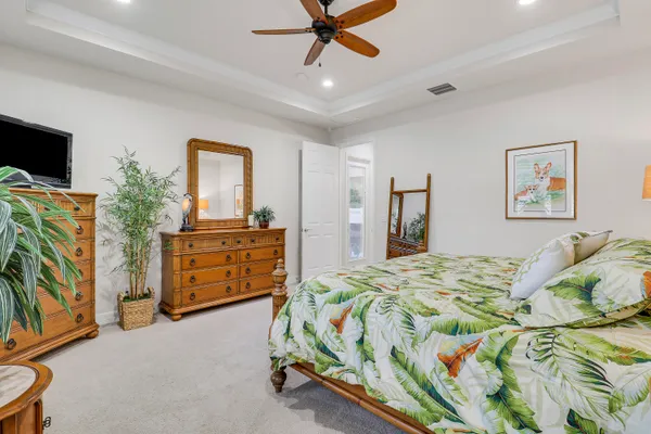 a bedroom with a bed and a flat tv screen on dresser